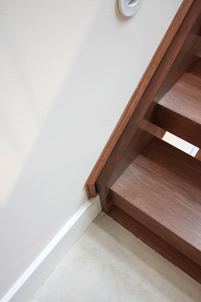 Foto de escalera suspendida moderna de tamaño medio con escalones de madera, barandilla de vidrio y panelado