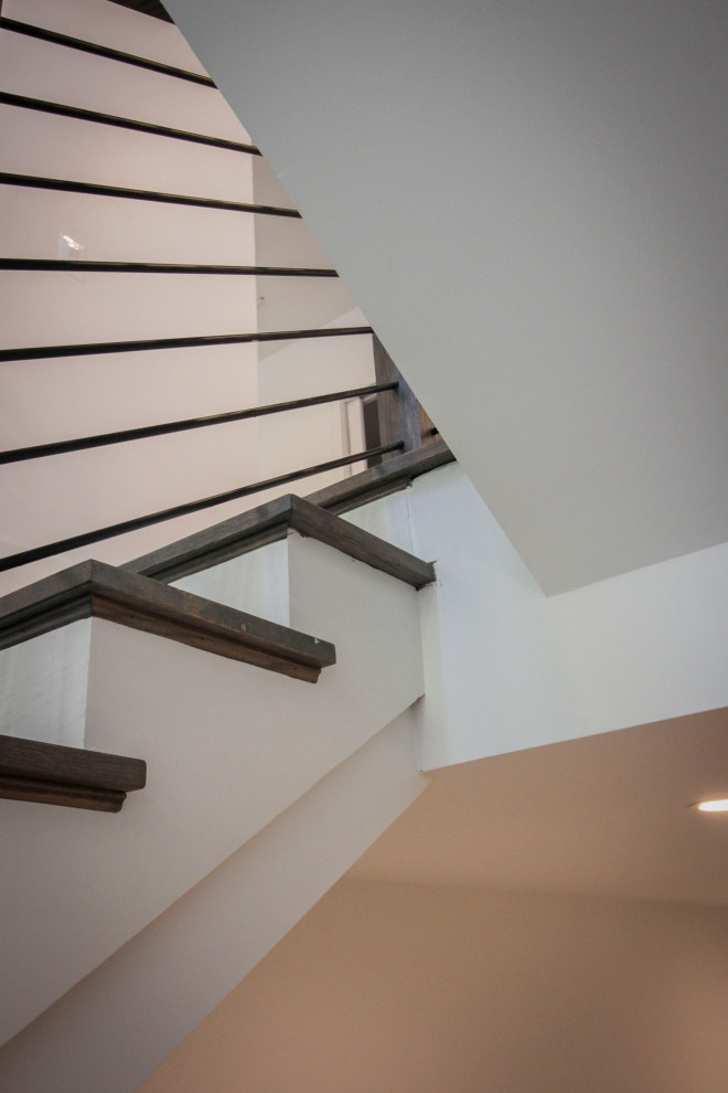 Modelo de escalera en U tradicional renovada de tamaño medio con escalones de madera, contrahuellas de madera, barandilla de metal y panelado