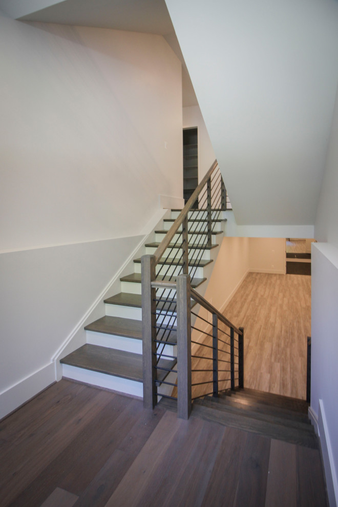 Photo of a medium sized traditional wood u-shaped metal railing staircase in DC Metro with wood risers and panelled walls.