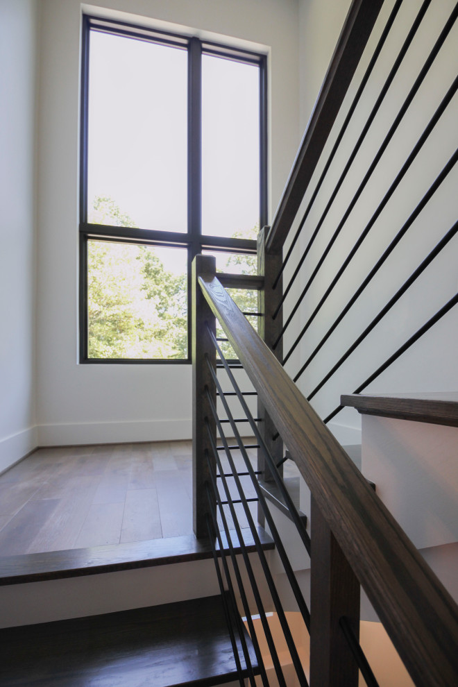 Ejemplo de escalera en U clásica renovada de tamaño medio con escalones de madera, contrahuellas de madera, barandilla de metal y panelado