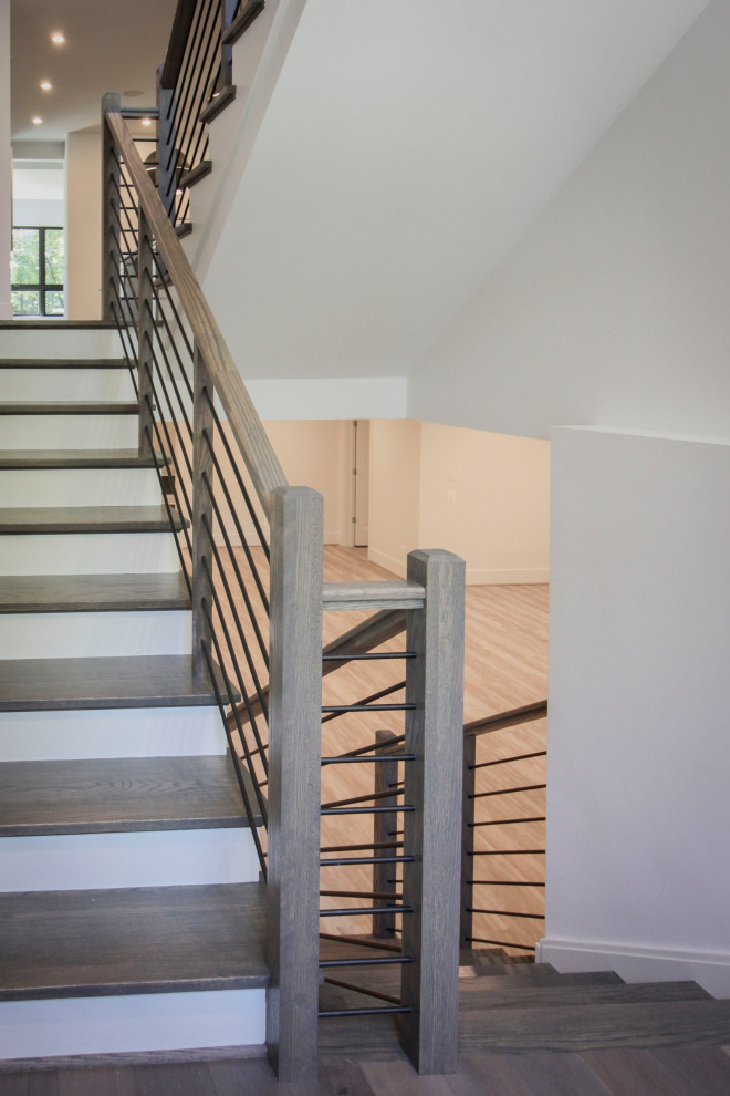 Imagen de escalera en U tradicional renovada de tamaño medio con escalones de madera, contrahuellas de madera, barandilla de metal y panelado