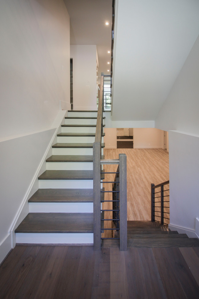 Свежая идея для дизайна: п-образная деревянная лестница среднего размера в стиле неоклассика (современная классика) с деревянными ступенями, металлическими перилами и панелями на части стены - отличное фото интерьера