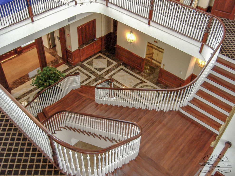 Пример оригинального дизайна: огромная деревянная лестница на больцах в классическом стиле с деревянными ступенями и деревянными перилами