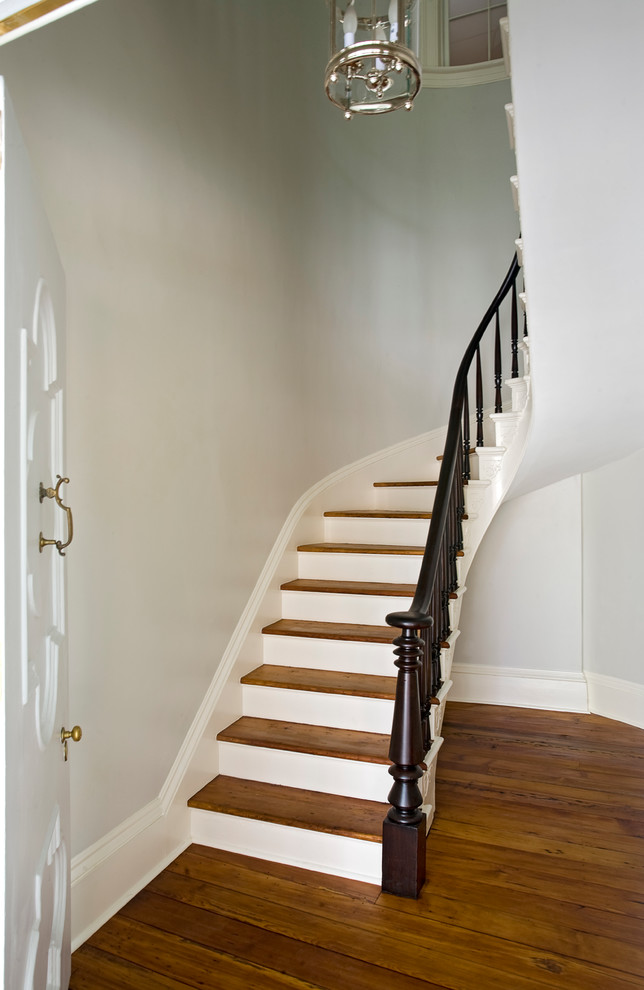 Ejemplo de escalera suspendida clásica de tamaño medio con escalones de madera y contrahuellas de madera