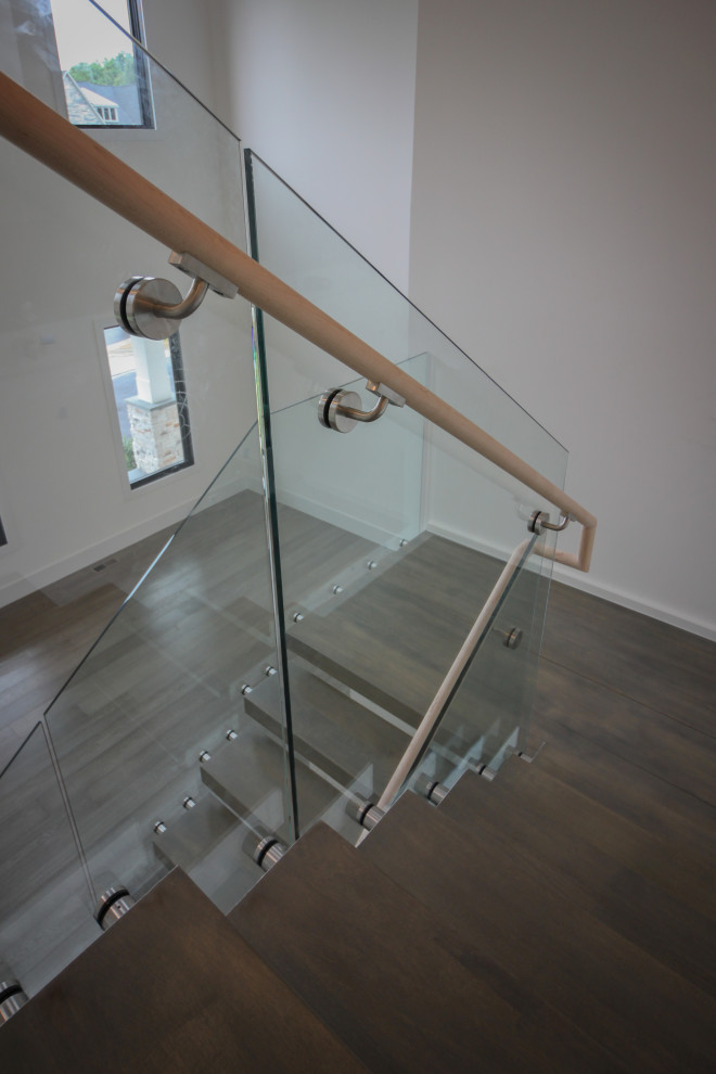 Источник вдохновения для домашнего уюта: огромная лестница на больцах в стиле модернизм с деревянными ступенями и стеклянными перилами