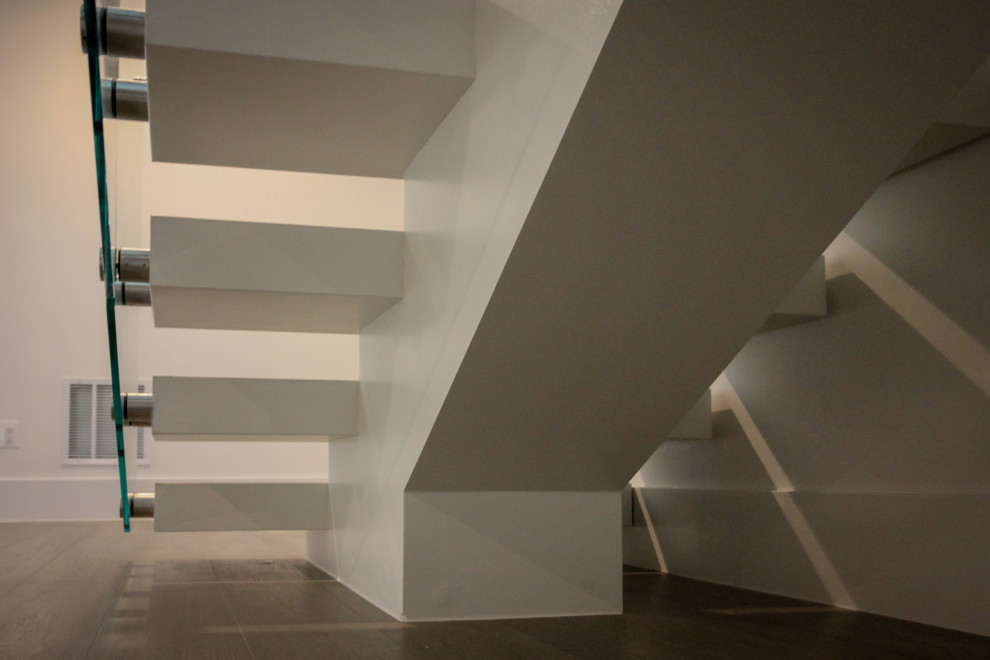 Foto de escalera suspendida minimalista extra grande con escalones de madera y barandilla de vidrio