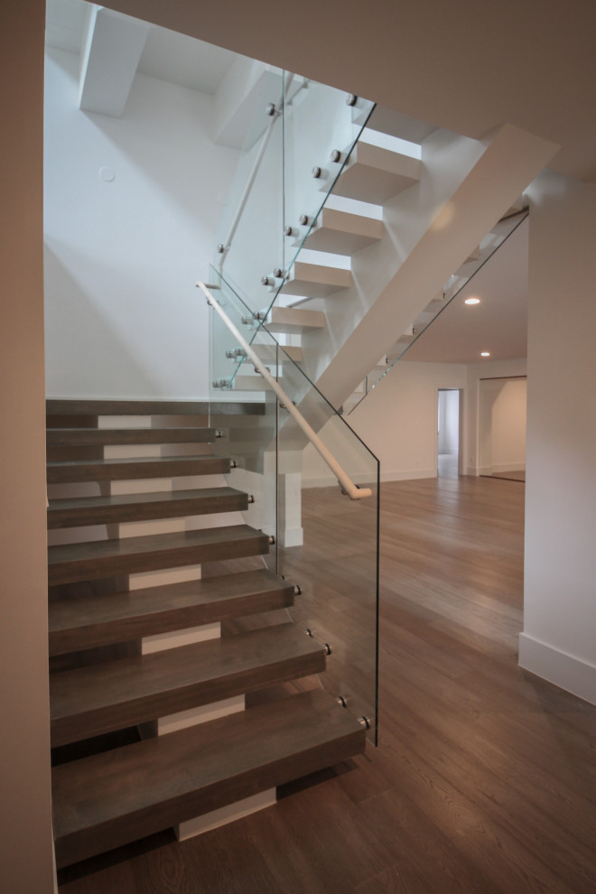 Inspiration for a huge modern wooden floating glass railing staircase remodel in DC Metro
