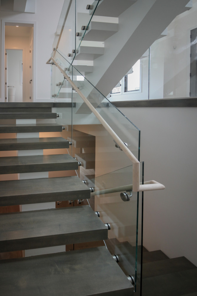 Imagen de escalera suspendida minimalista extra grande con escalones de madera y barandilla de vidrio