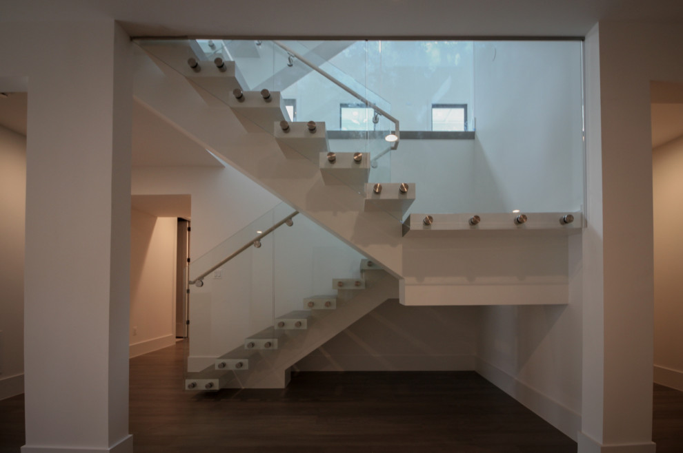 Inspiration pour un très grand escalier flottant minimaliste avec des marches en bois et un garde-corps en verre.