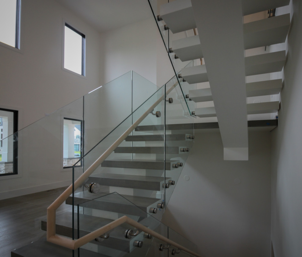 Источник вдохновения для домашнего уюта: огромная лестница на больцах в стиле модернизм с деревянными ступенями и стеклянными перилами