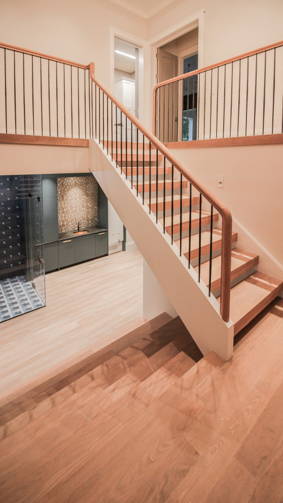 Diseño de escalera en U minimalista grande con escalones de madera, contrahuellas de madera, barandilla de metal y papel pintado