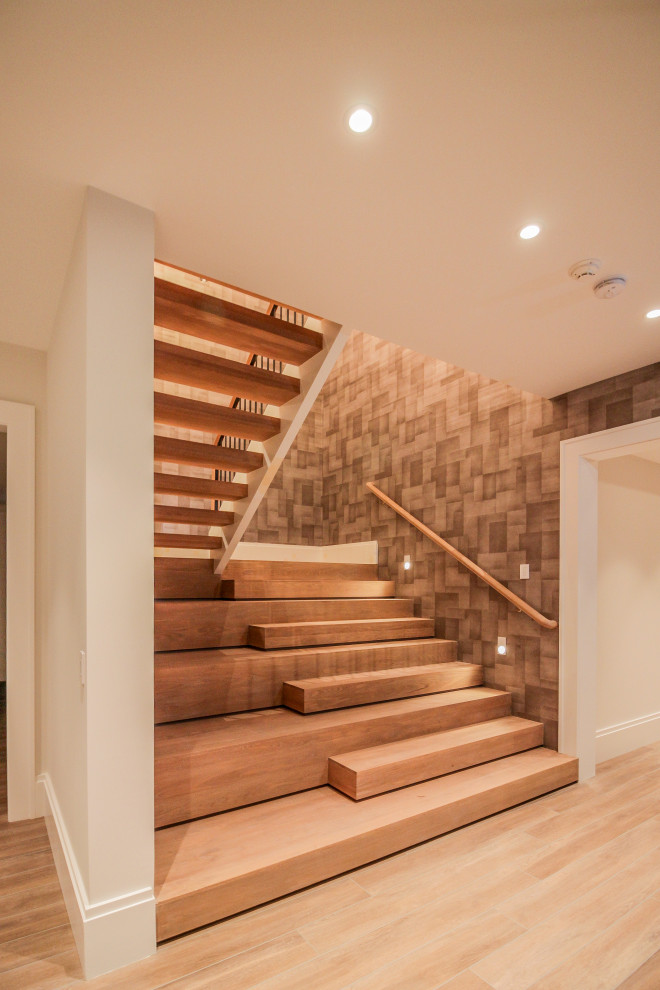 Idée de décoration pour un grand escalier minimaliste en U avec des marches en bois, des contremarches en bois, un garde-corps en métal et du papier peint.