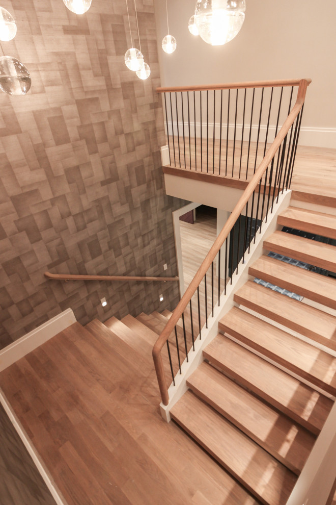 Inspiration for a large modern wood u-shaped metal railing staircase in DC Metro with wood risers and wallpapered walls.