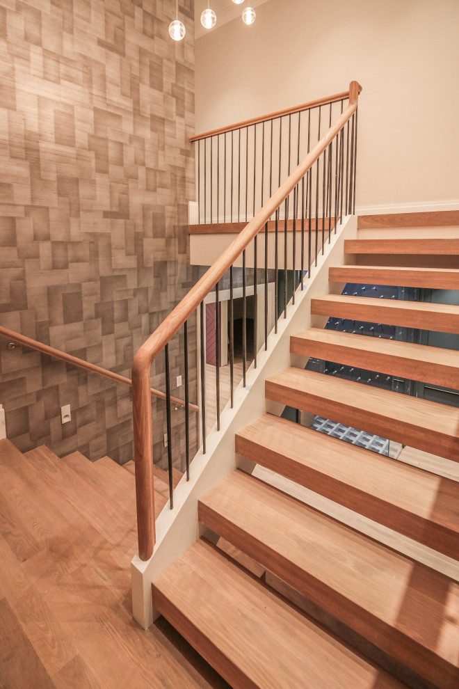 Inspiration pour un grand escalier minimaliste en U avec des marches en bois, des contremarches en bois, un garde-corps en métal et du papier peint.