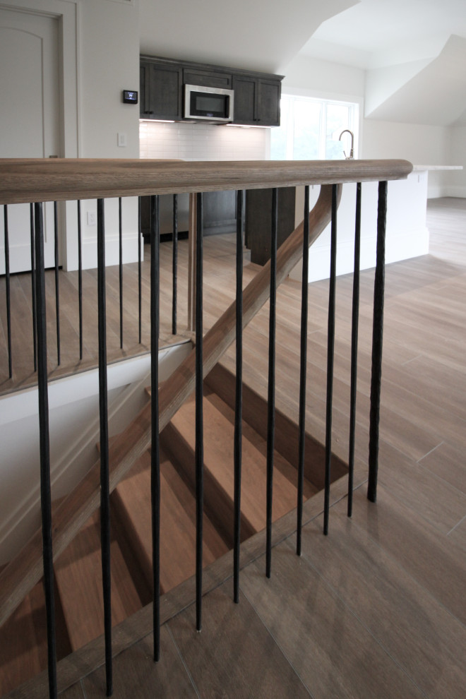 Idées déco pour un grand escalier moderne en U avec des marches en bois, des contremarches en bois, un garde-corps en métal et du papier peint.