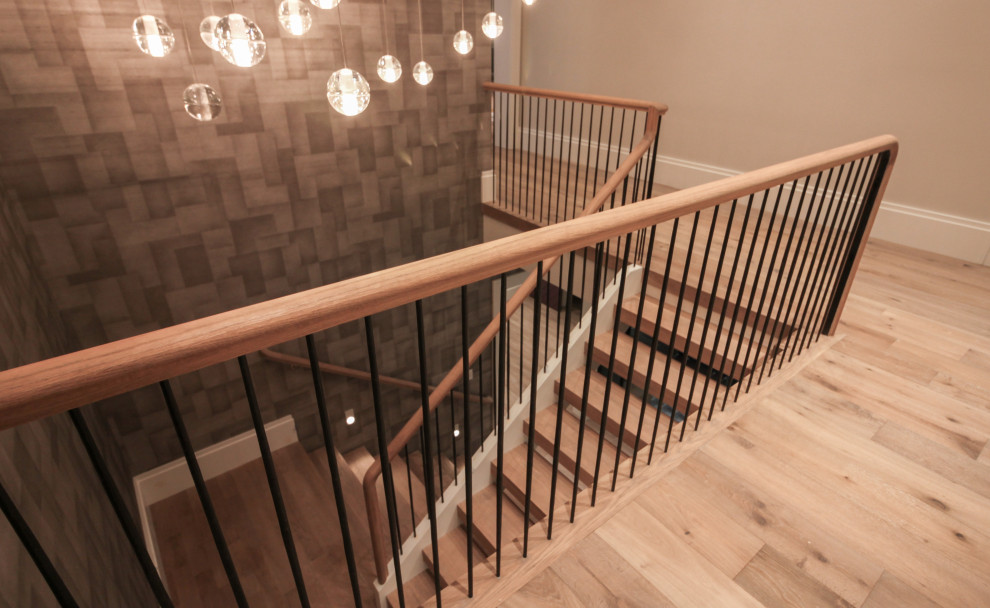 На фото: большая п-образная деревянная лестница в стиле модернизм с деревянными ступенями, металлическими перилами и обоями на стенах