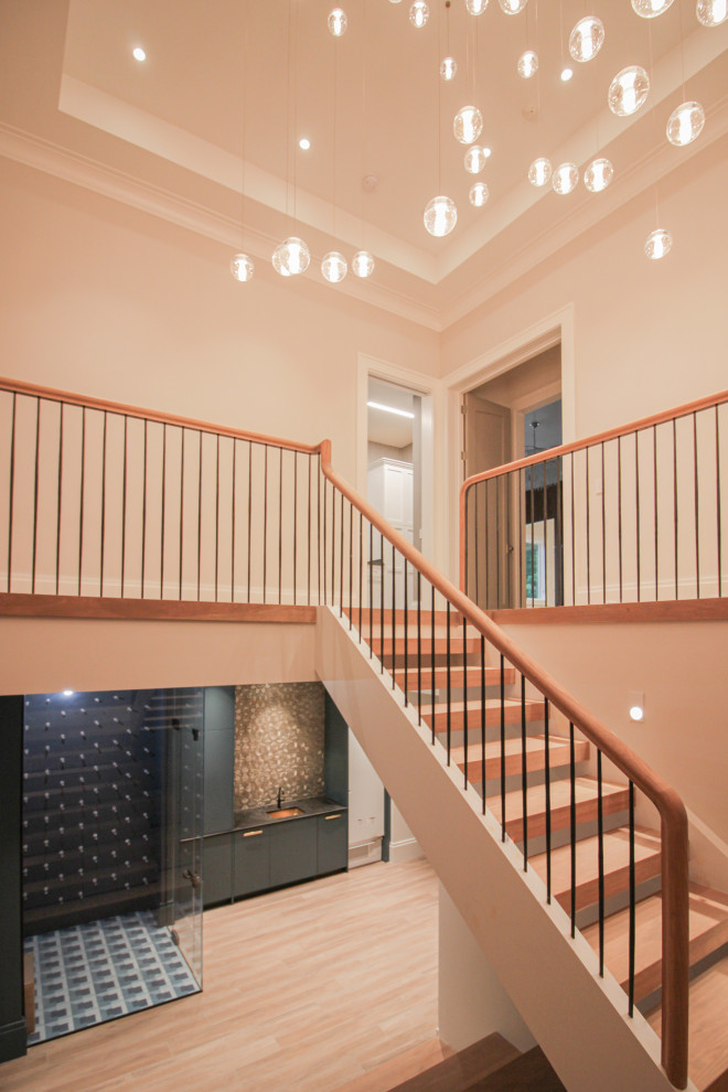 Foto de escalera en U minimalista grande con escalones de madera, contrahuellas de madera, barandilla de metal y papel pintado