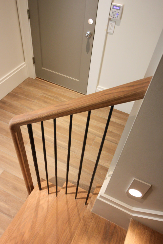 Ejemplo de escalera en U minimalista grande con escalones de madera, contrahuellas de madera, barandilla de metal y papel pintado