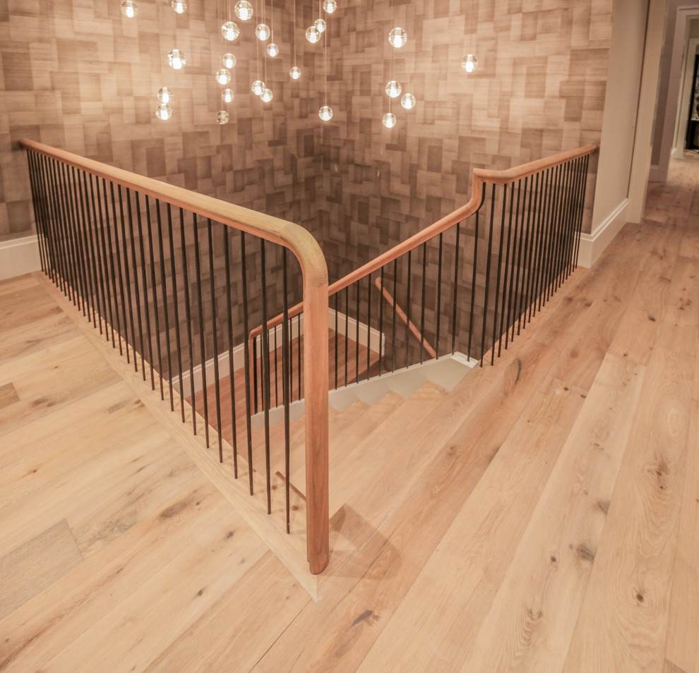 Foto de escalera en U minimalista grande con escalones de madera, contrahuellas de madera, barandilla de metal y papel pintado