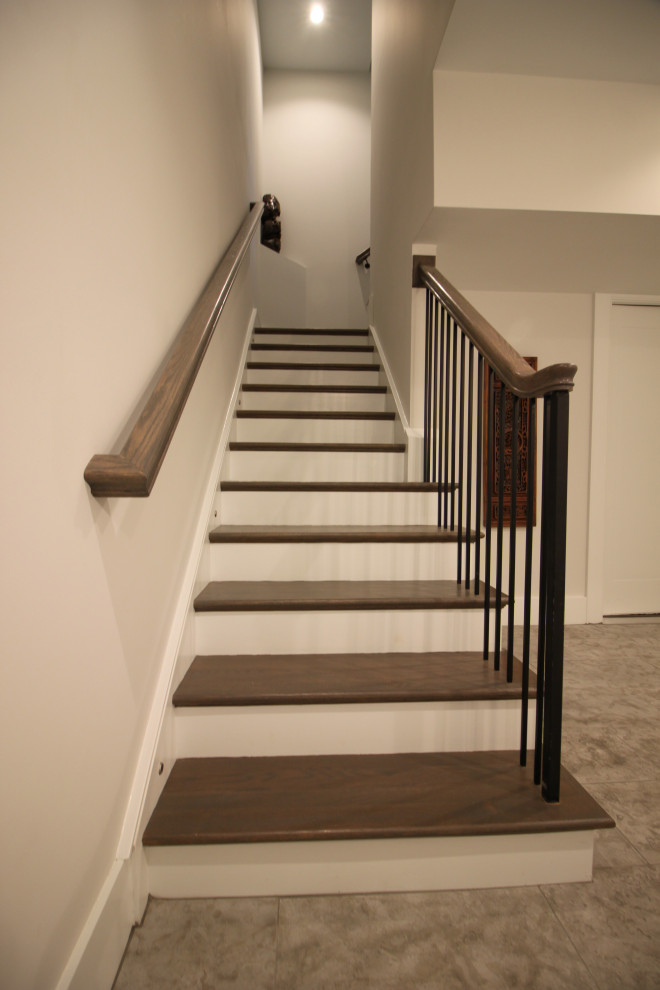 Foto de escalera en L clásica renovada grande con escalones de madera, contrahuellas de madera pintada, barandilla de metal y panelado