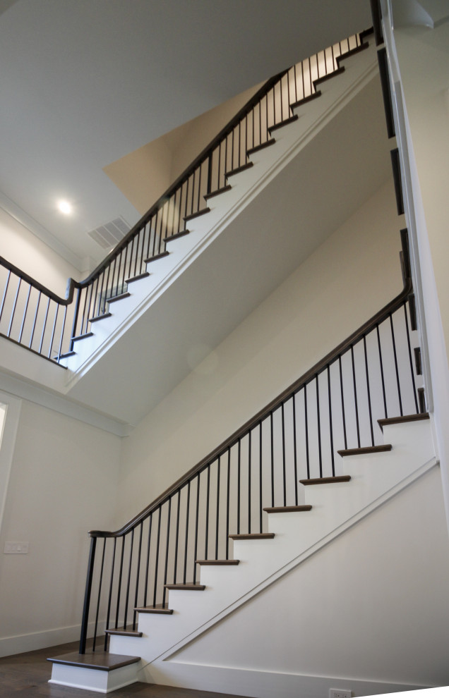 Inspiration for a large traditional wood l-shaped metal railing staircase in DC Metro with painted wood risers and panelled walls.