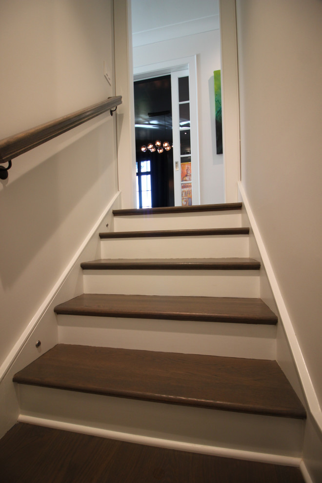 Example of a large transitional wooden l-shaped metal railing and wall paneling staircase design in DC Metro with painted risers