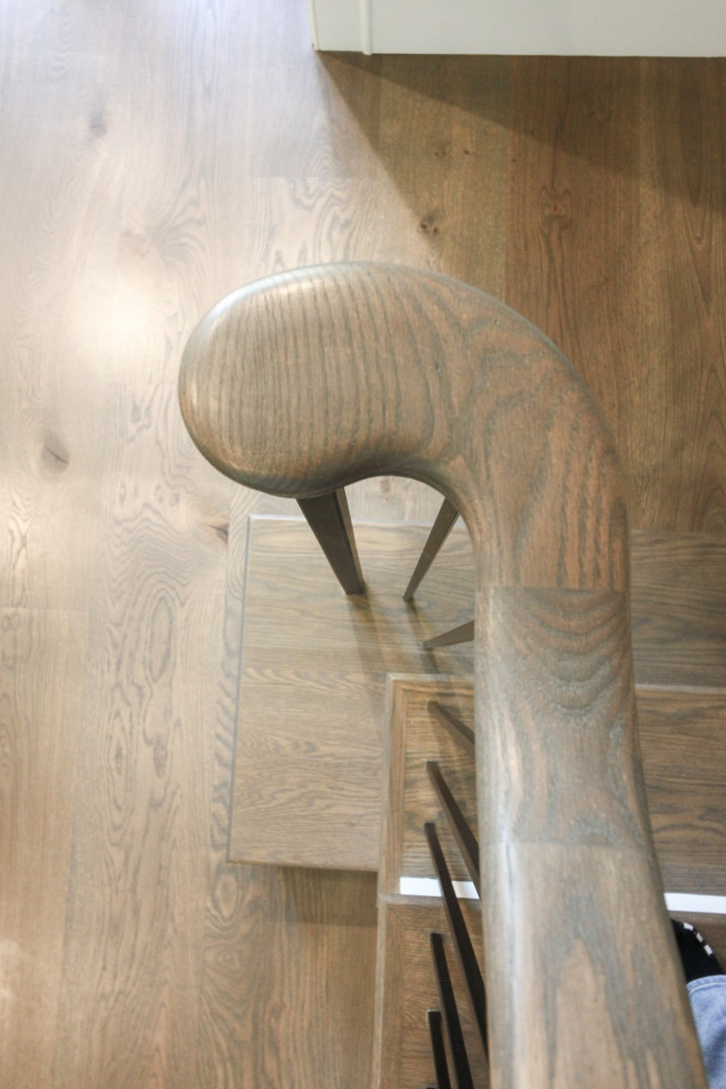 Foto di una grande scala a "L" classica con pedata in legno, alzata in legno verniciato, parapetto in metallo e pannellatura