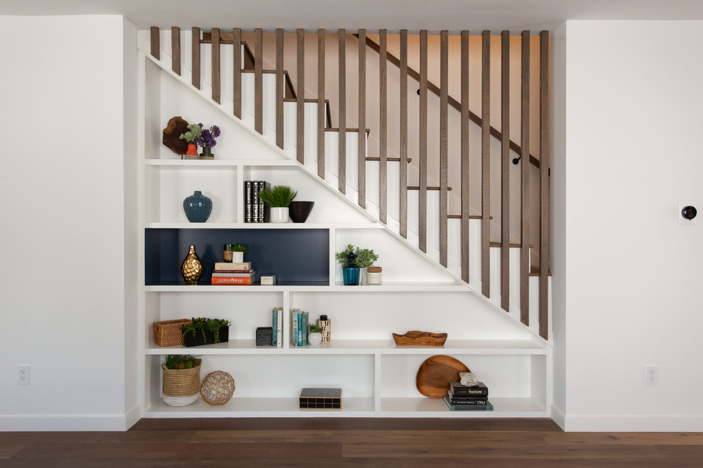 Стильный дизайн: прямая лестница в стиле неоклассика (современная классика) с деревянными ступенями, крашенными деревянными подступенками, деревянными перилами и кладовкой или шкафом под ней - последний тренд