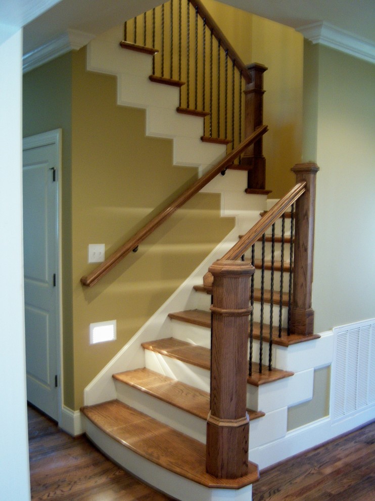 Ejemplo de escalera en U clásica de tamaño medio con escalones de madera y contrahuellas de madera