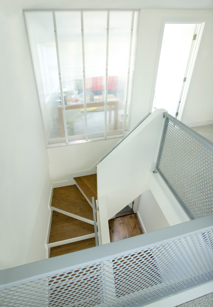 Foto de escalera curva contemporánea grande con escalones de madera y contrahuellas de madera pintada