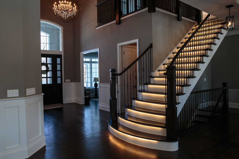 Стильный дизайн: большая прямая лестница в стиле неоклассика (современная классика) с деревянными ступенями и крашенными деревянными подступенками - последний тренд