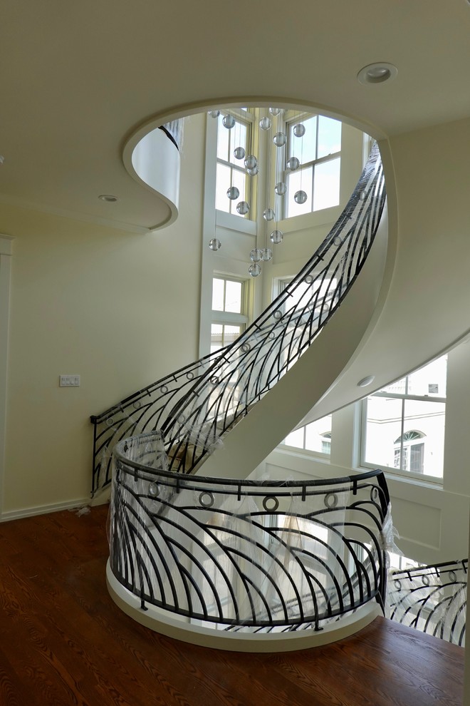 Inspiration för stora exotiska svängda trappor i trä, med sättsteg i målat trä och räcke i metall