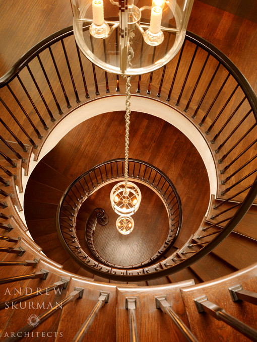 Foto de escalera curva clásica de tamaño medio con escalones de madera, contrahuellas de madera y barandilla de madera