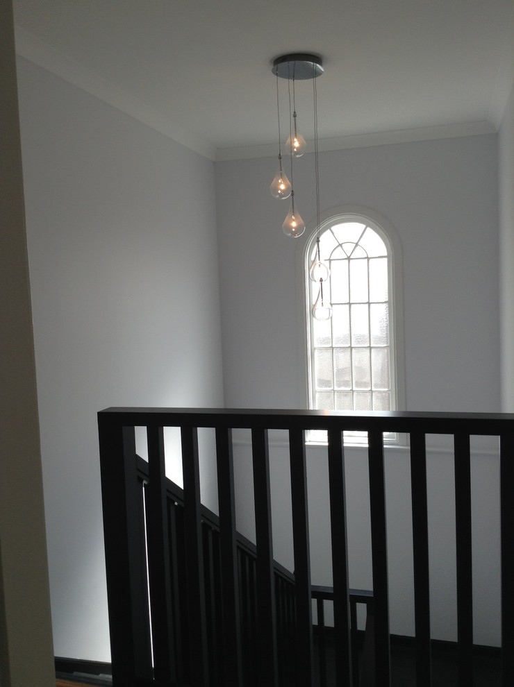 Cette image montre un escalier peint minimaliste en L de taille moyenne avec des marches en bois peint.