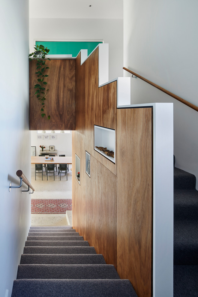 Example of a small trendy carpeted u-shaped wood railing staircase design in Melbourne with carpeted risers
