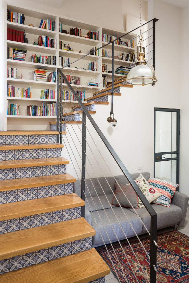 Ejemplo de escalera en L urbana con escalones de madera, contrahuellas con baldosas y/o azulejos y barandilla de cable
