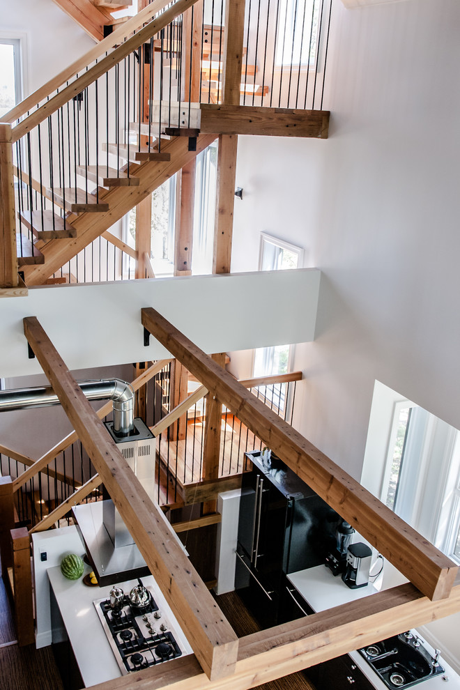 Inspiration pour un grand escalier sans contremarche minimaliste en U avec des marches en bois et un garde-corps en bois.