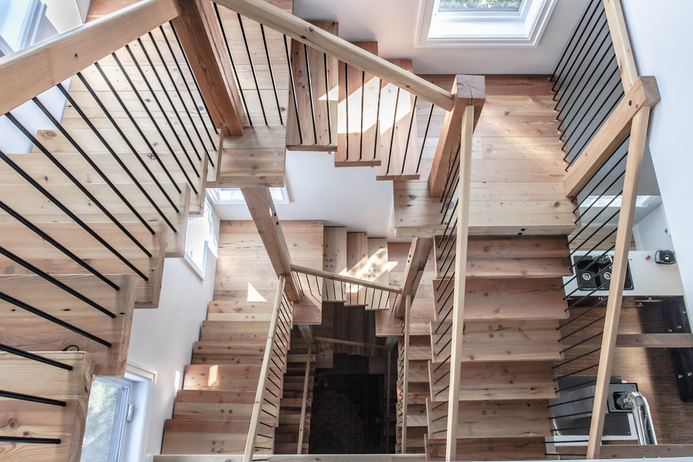 Large minimalist wooden u-shaped staircase photo in Other with wooden risers
