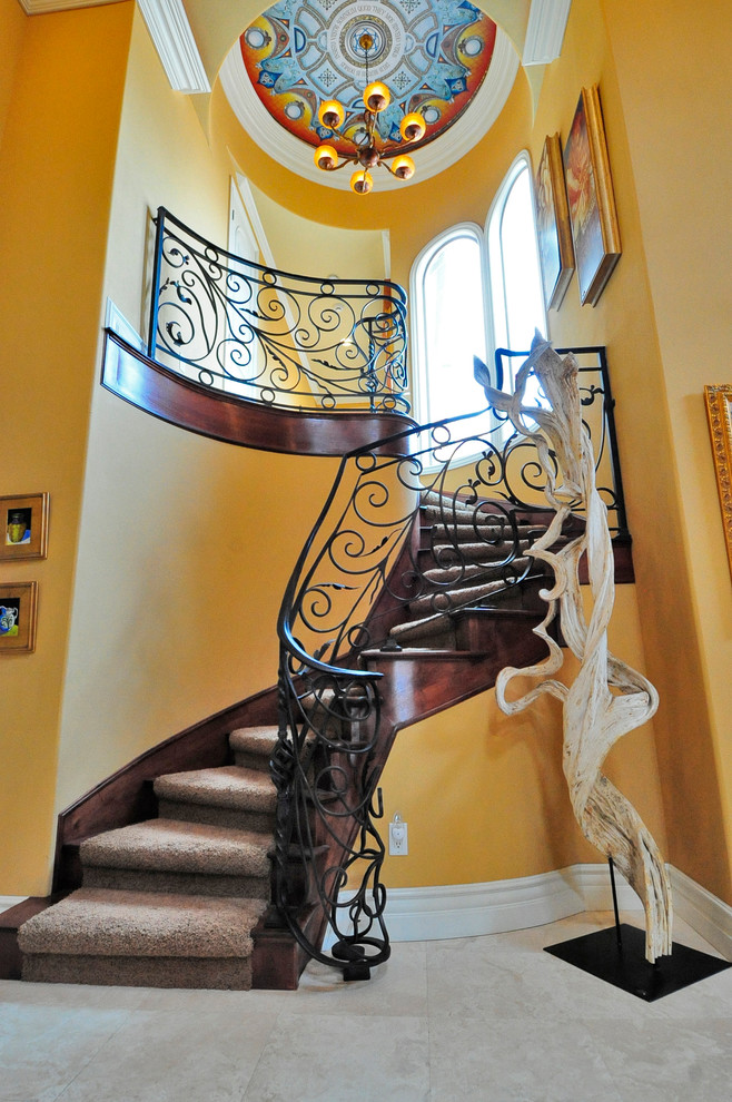 Cette photo montre un escalier courbe méditerranéen de taille moyenne avec des marches en moquette, des contremarches en bois et un garde-corps en métal.