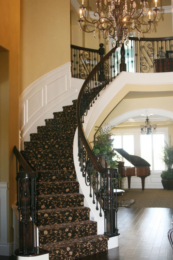 Inspiration for a large timeless carpeted curved mixed material railing staircase remodel in Boise with carpeted risers