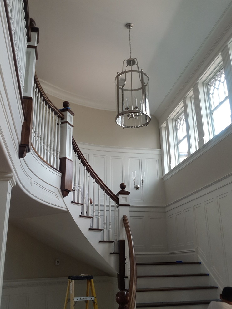 Example of a mid-sized classic wooden curved wood railing staircase design in Bridgeport with painted risers