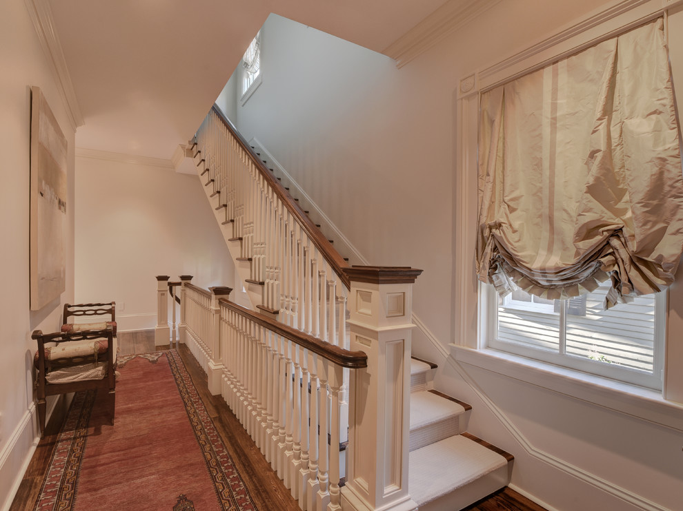 Example of a large classic carpeted straight wood railing staircase design in New Orleans with carpeted risers