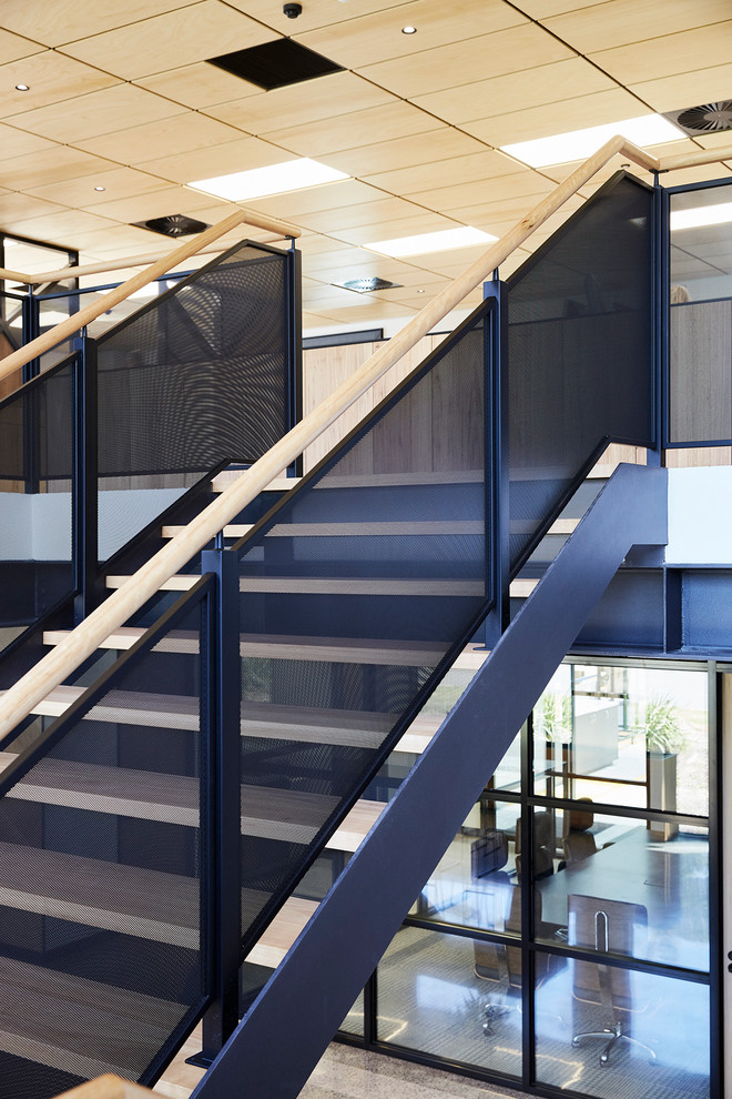 Стильный дизайн: большая п-образная металлическая лестница в современном стиле с деревянными ступенями и деревянными перилами - последний тренд