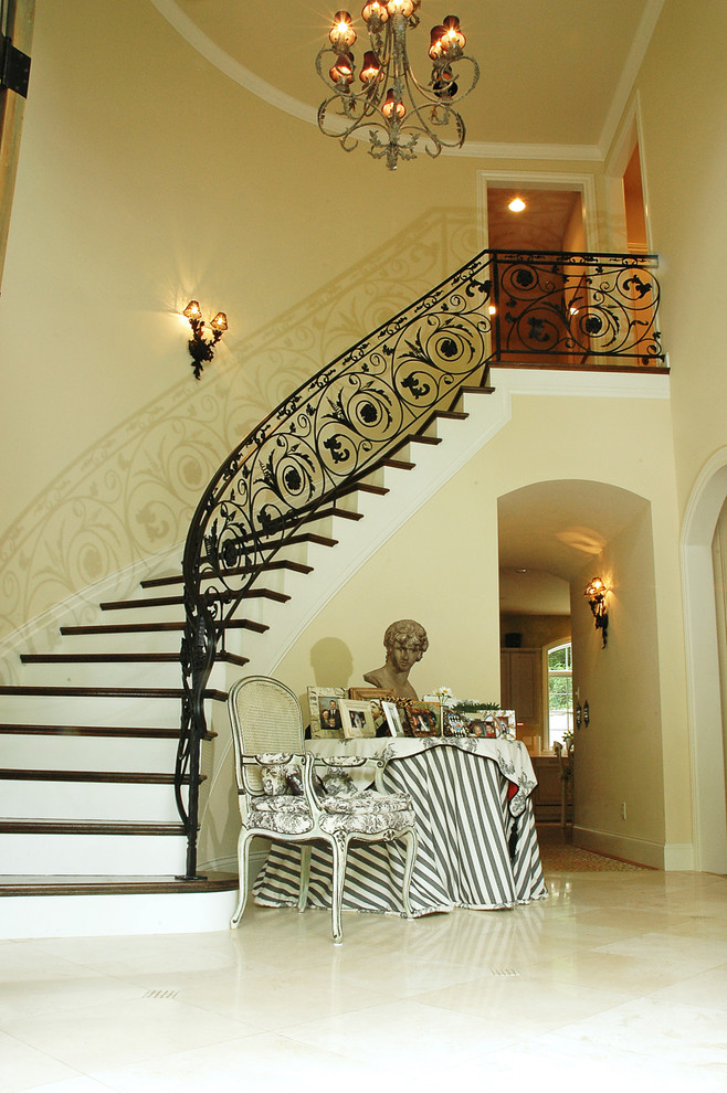 Ejemplo de escalera curva tradicional grande con escalones de madera y contrahuellas de madera pintada