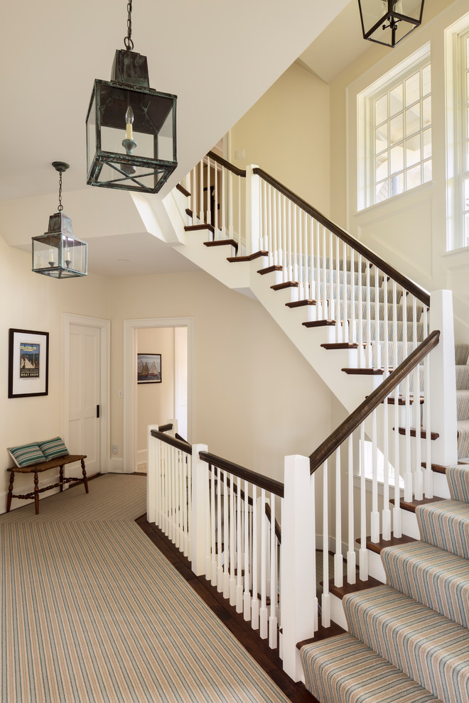 Design ideas for a medium sized coastal carpeted l-shaped wood railing staircase in Milwaukee with carpeted risers.