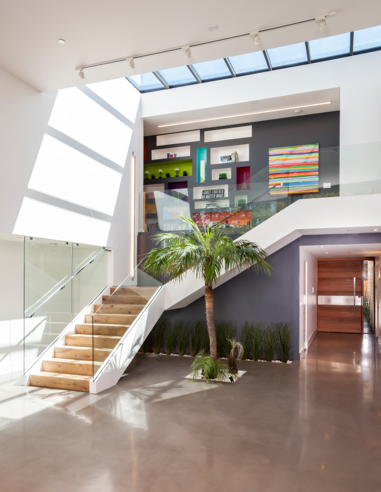 Photo of a large contemporary wood l-shaped glass railing staircase in San Francisco with wood risers.