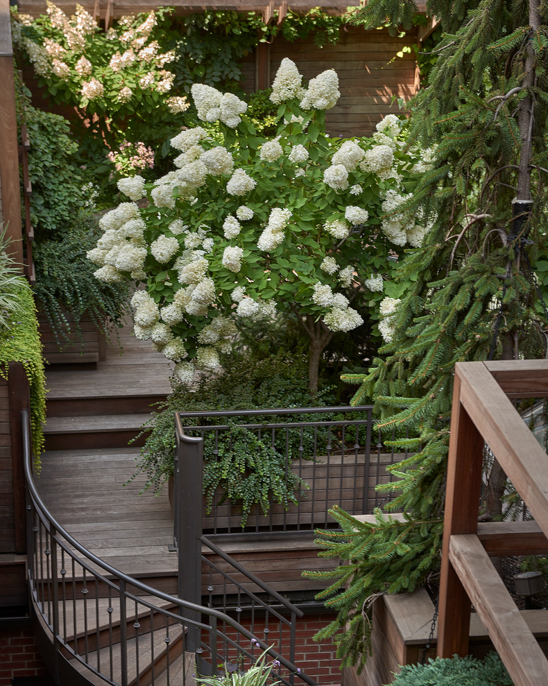 На фото: маленькая винтовая лестница в современном стиле с деревянными ступенями и металлическими перилами для на участке и в саду с