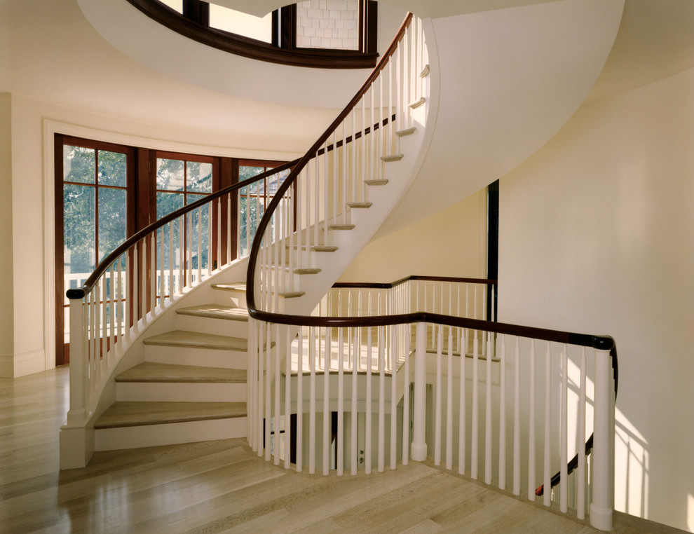 Aménagement d'un grand escalier peint hélicoïdal classique avec des marches en bois.
