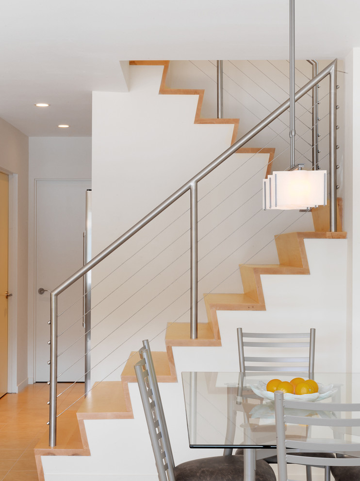 Cette image montre un escalier design en U avec des marches en bois, des contremarches en bois et éclairage.