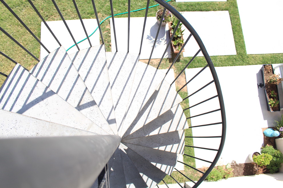 Foto de escalera de caracol tradicional de tamaño medio con escalones de metal, contrahuellas de metal y barandilla de metal